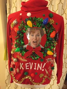 a red sweater with an image of a woman's face in the center and christmas decorations around her neck