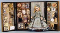 a doll is in a display case with many different things on it's sides