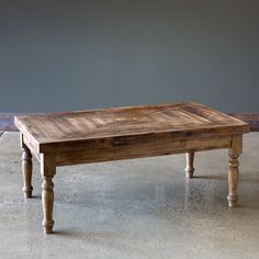 a wooden table sitting on top of a cement floor