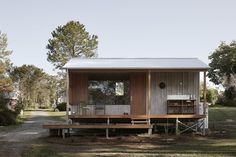 a small wooden cabin sitting on top of a lush green field