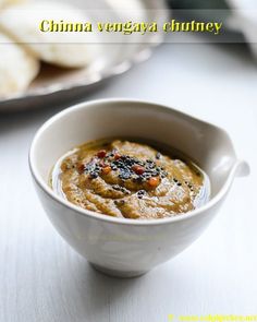 a white bowl filled with food sitting on top of a table next to a plate