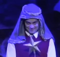 a man wearing a purple outfit with a star on it