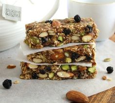 three granola bars stacked on top of each other with nuts and raisins