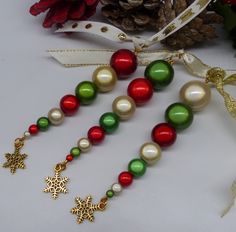 christmas decorations and pine cones on a white table with red, green and gold ornaments