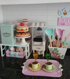 there is a toy kitchen set up on the counter with coffee cups and spoons