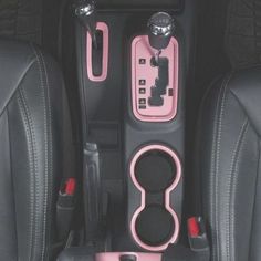 the interior of a car with pink and black accessories in it's center console