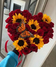 a bouquet of red roses and sunflowers with a butterfly on it