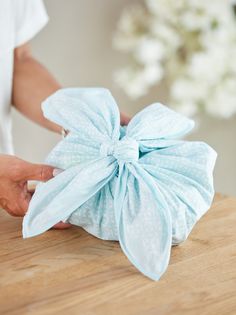 a woman is holding a blue cloth flower