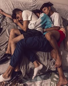 two people sleeping on a bed with one person wearing slippers and the other in shorts