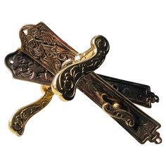 an ornate gold and black tie clip