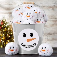 a bucket filled with white stuffed animals sitting next to a christmas tree