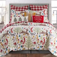 the comforter is decorated with deers and pine trees in red, green, yellow, white and blue