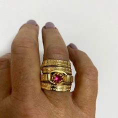 "This captivating, multiband, gold-filled ring features a stunning pink ruby and a beautiful Hebrew engraving of the Jewish Psalm Woman of Valor (Eshet Chayil.) With the ruby representing passion and the psalm a romantic verse from Husband to wife on Sabbath eve, this piece makes for a meaningful anniversary gift, engagement, or promise ring. The psalm is also fittingly an acrostic - every first letter in verse creates the entire Hebrew alphabet from the letter 'Aleph' to 'Tav', representing a c Formal Gold Stackable Ruby Rings, Gold Ruby Rings With 17 Jewels, Luxury Gold Ruby Stackable Ring, Spiritual Gold Engraved Gemstone Ring, Gold Engraved Open Ring With Gemstone, Wedding Stackable Ruby Rings In Gold, Gold Oval Pink Sapphire Rings, Gold Ruby Stackable Jewelry, Gold Ruby Rings Fine Jewelry