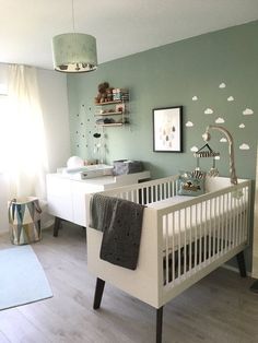 a baby's room with a crib, dresser and bed