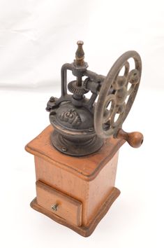 an old fashioned spinning wheel on top of a wooden stand against a white background,