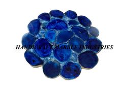 blue glass pebbles are arranged in the shape of a flower on a white background with text that reads, handmade marble pictures