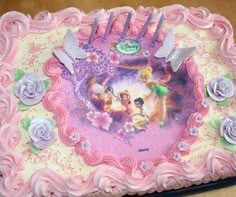 there is a pink cake with tinkerbells on it