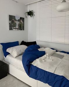 a bed with blue and white sheets in a room