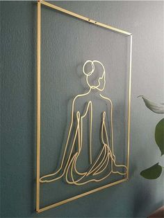 a gold framed art piece with a woman's body in the shape of a man