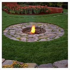 a fire pit in the middle of some grass