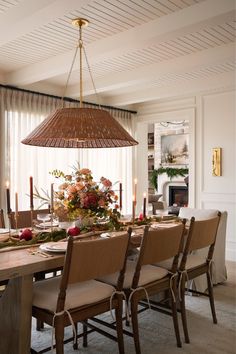 a dining room table with chairs and a chandelier hanging from it's ceiling