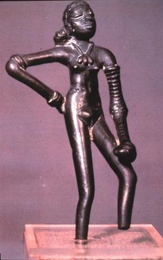 a bronze statue of a woman with her arms behind her back and hands on her hips