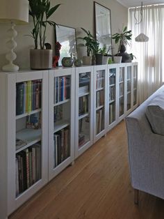 a living room filled with lots of books and plants