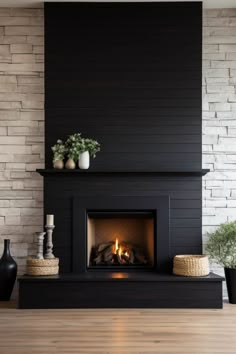 a fireplace in a living room with white brick walls and black painted wood paneling