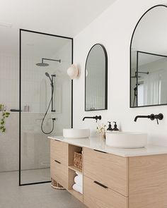 a bathroom with two sinks, mirrors and a shower stall in it's corner