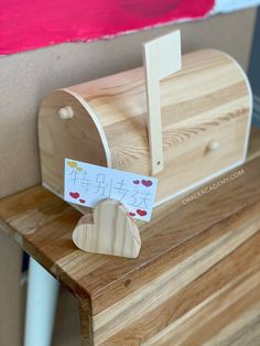 a wooden mailbox sitting on top of a wooden table