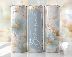 three tins with flowers on them sitting next to a computer keyboard in front of a wall