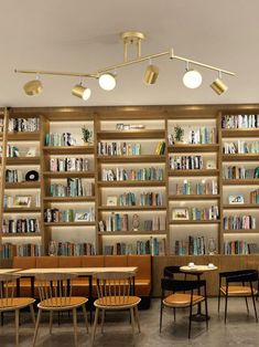 a room with many bookshelves filled with lots of books and chairs next to each other