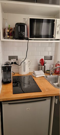 a kitchen counter with a microwave, toaster and coffee maker on top of it