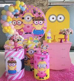 a pink and yellow birthday party with balloons, decorations and minion cake toppers