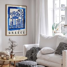 a living room filled with white furniture and pillows on top of a wooden coffee table