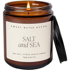 a candle that is sitting on top of a white surface with the words salt and sea in it