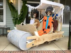 a group of people dressed up as skeletons in a sleigh on a porch