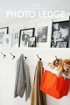 there is a coat rack with pictures on the wall and two coats hanging from hooks