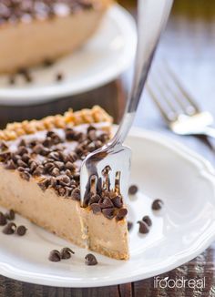 a slice of chocolate chip cheesecake on a white plate with a fork in it