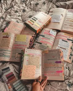 an open book laying on top of a bed covered in lots of papers and color swatches