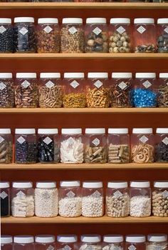 the shelves are filled with many different types of cookies and candies in glass jars