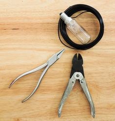 a pair of pliers sitting on top of a wooden table next to a cord