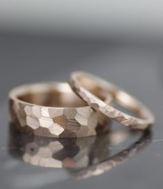 two wedding rings sitting on top of a table