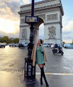 a woman standing next to a lamp post