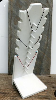 a white sculpture with multiple necklaces on it