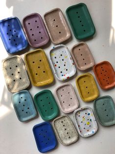 many different colored trays with holes in them on a white surface, one is empty