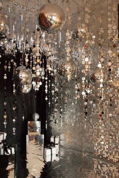 a room filled with lots of shiny balls hanging from the ceiling