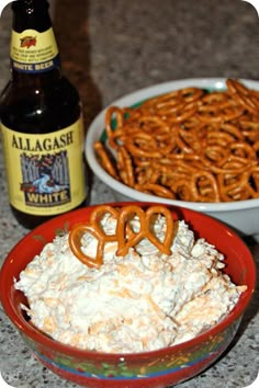 some pretzels and beer are sitting on the counter next to a bowl of food