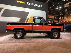 a red and black truck on display at a car show