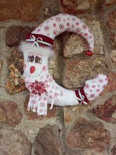 a snowman wreath hanging on the side of a stone wall